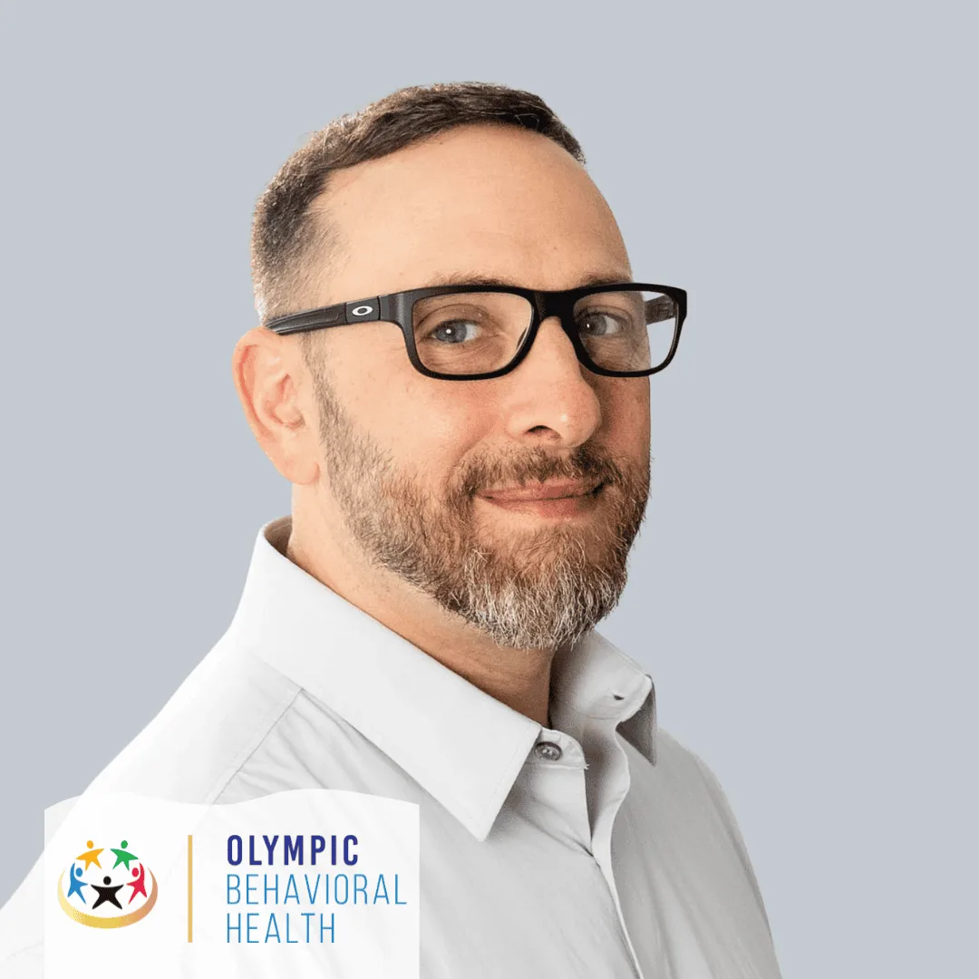 Adam Siegel, CAC, therapist and Certified Addictions Counselor at Olympic Behavioral Health, in glasses and white shirt