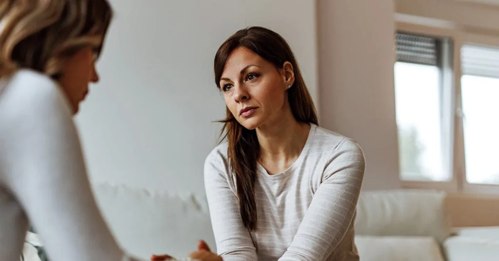 Woman listening attentively during a one-on-one therapy session, illustrating addiction therapy programs in Lantana, FL