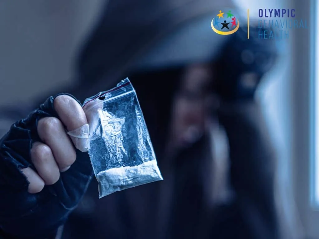Gloved hand holding a small bag of white powder, illustrating the question of whether angel dust is addictive