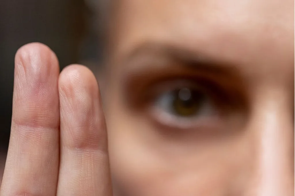 Close-up of an eye beside two raised fingers, the eye movement technique used in bilateral stimulation therapy