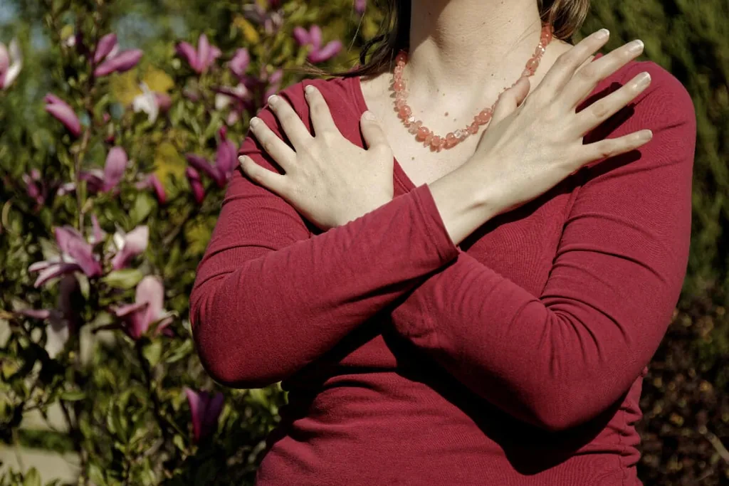 Woman crossing her arms over her chest in a butterfly hug, a bilateral stimulation technique for emotional regulation