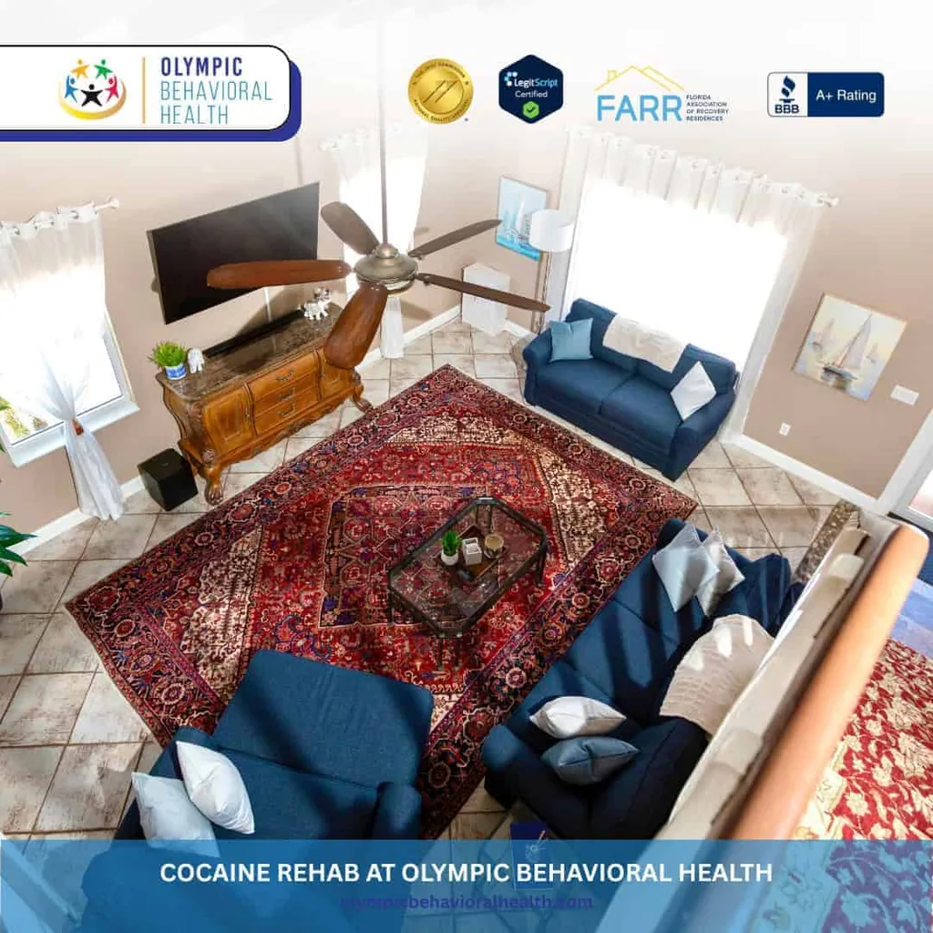 Living room with navy sofas and a red Persian rug, captioned Cocaine Rehab at Olympic Behavioral Health