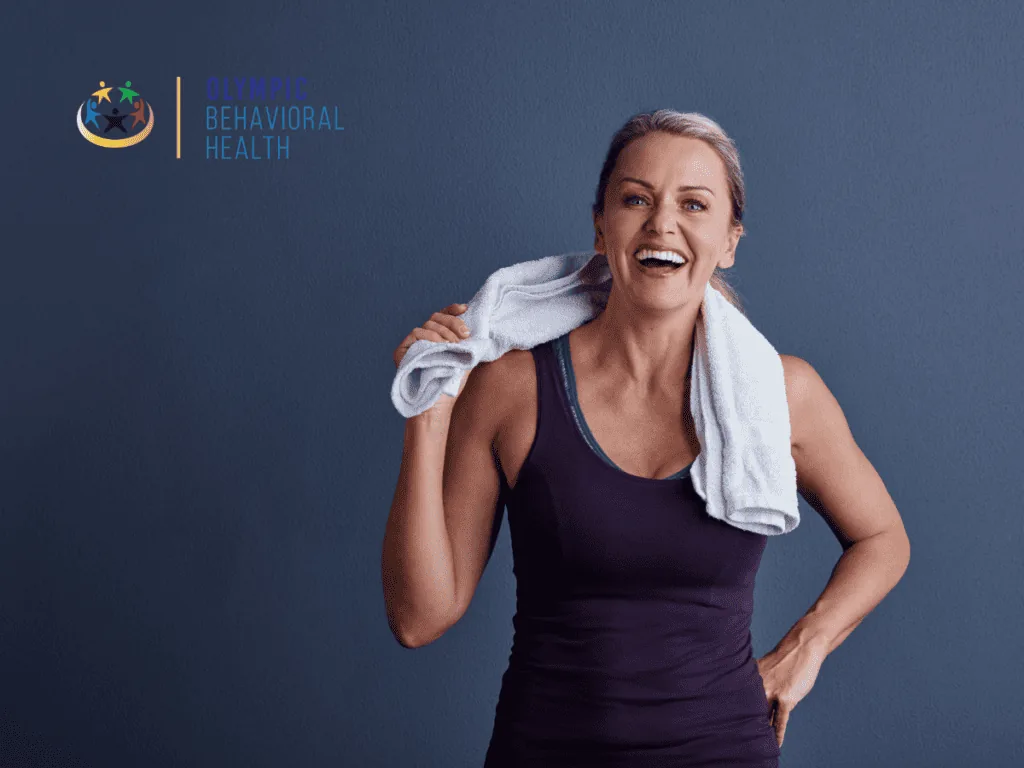 Smiling woman with a towel over her shoulders after exercise, showing the endorphin boost that comes from physical activity