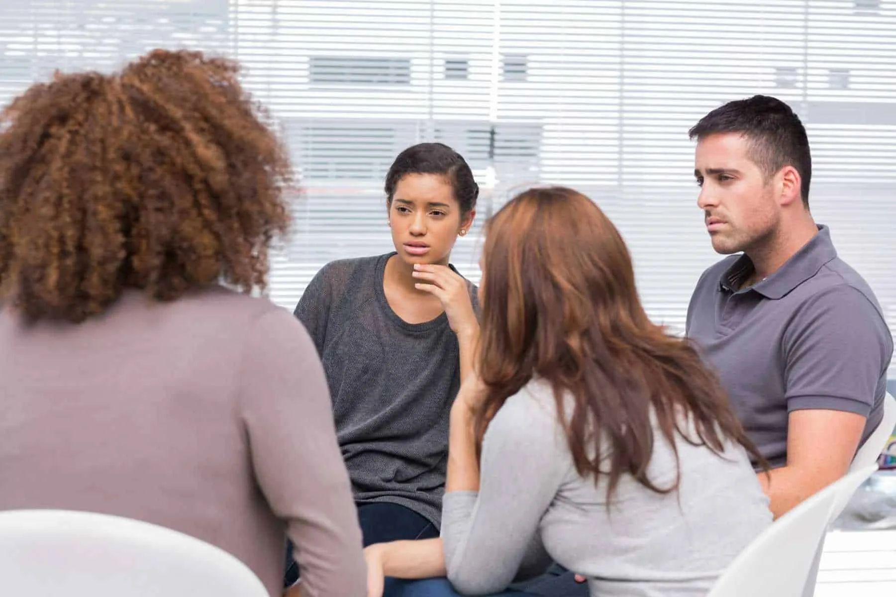 Small group therapy session with four adults talking in a circle, illustrating group therapy in Lantana, Florida