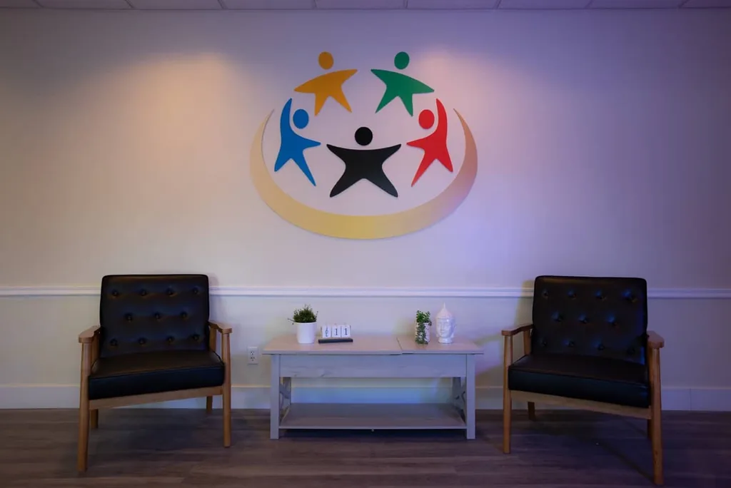 Olympic Behavioral Health lobby with two leather armchairs and a coffee table beneath the colorful logo mural