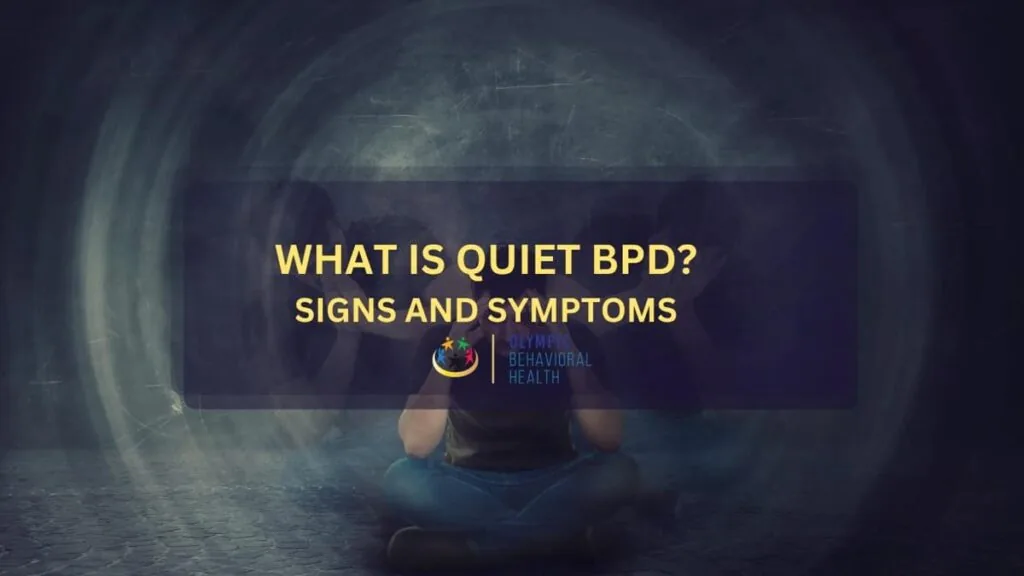 What Is Quiet BPD? Signs and Symptoms featured image showing a person sitting cross-legged in a dim room