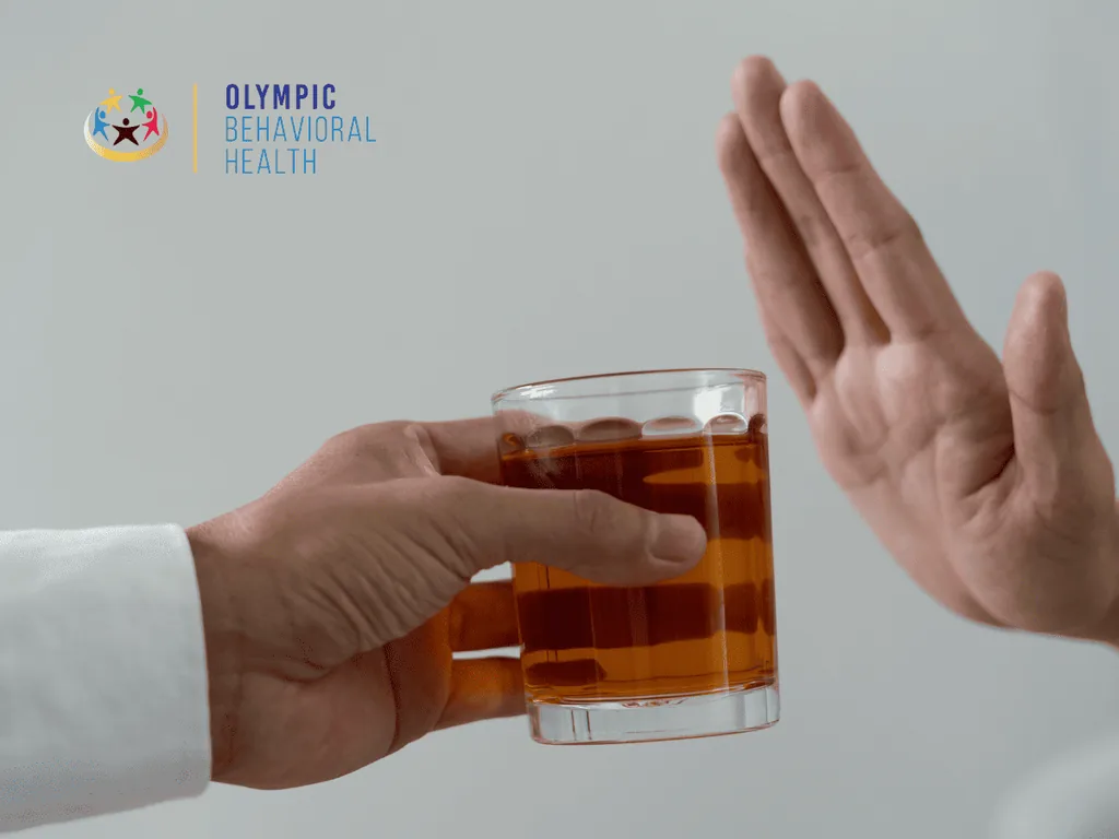 Hand raised to refuse a glass of whiskey being offered, illustrating important reminders for someone in rehab