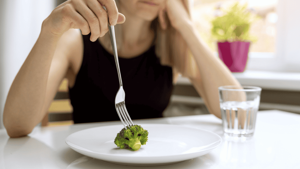 Women with eating disorder struggling to eat food.