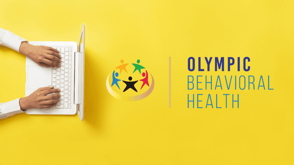 Picture of someone on a computer working with the Olympic Behavioral Health Logo.